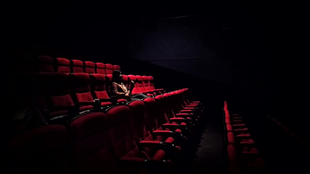 Mujer sola viendo una película en una sala de cine