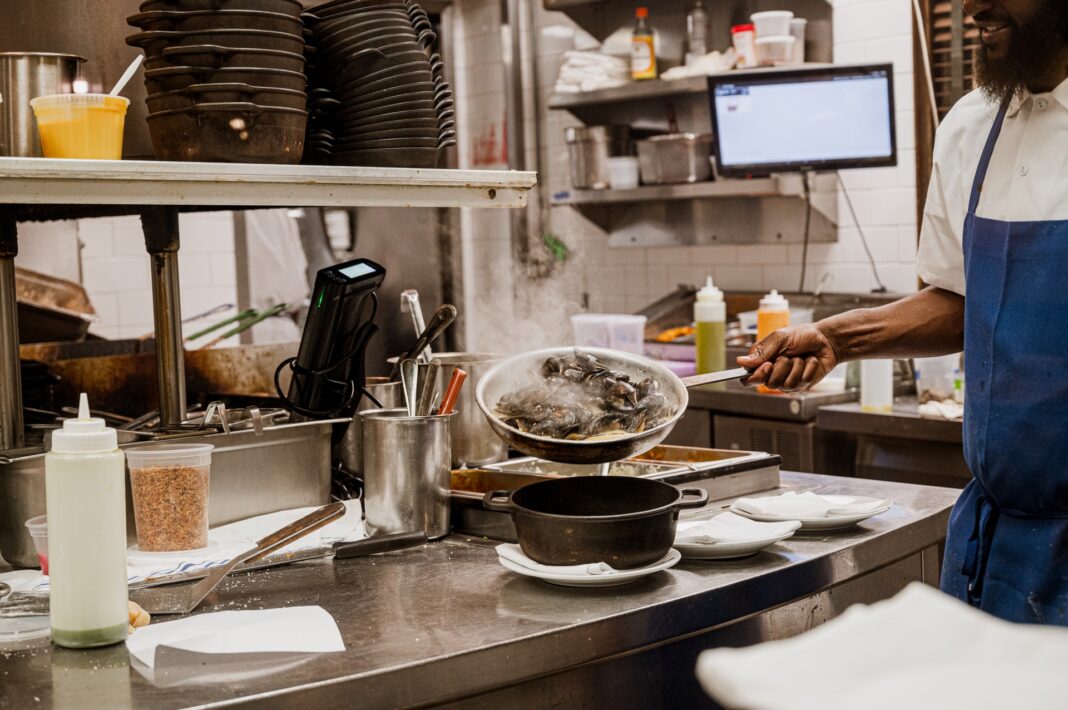 Cocinero usando maquinaria de hostelería en una cocina de un restaurante