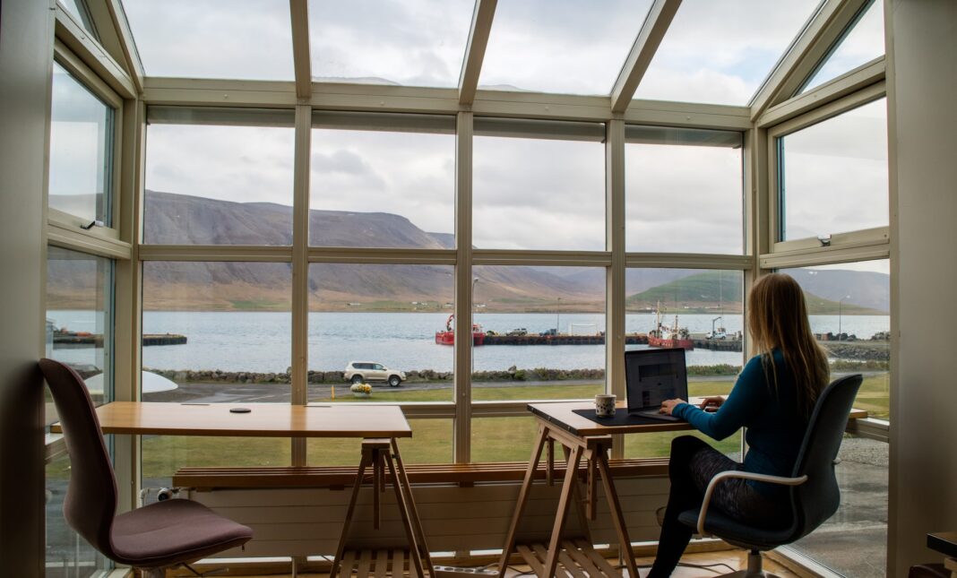 Trabajadora con ordenador portátil con vistas al mar